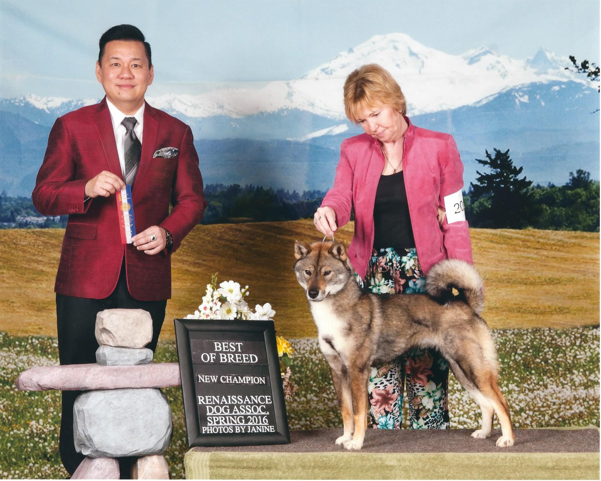 judge with handler and dog in front of a mountain