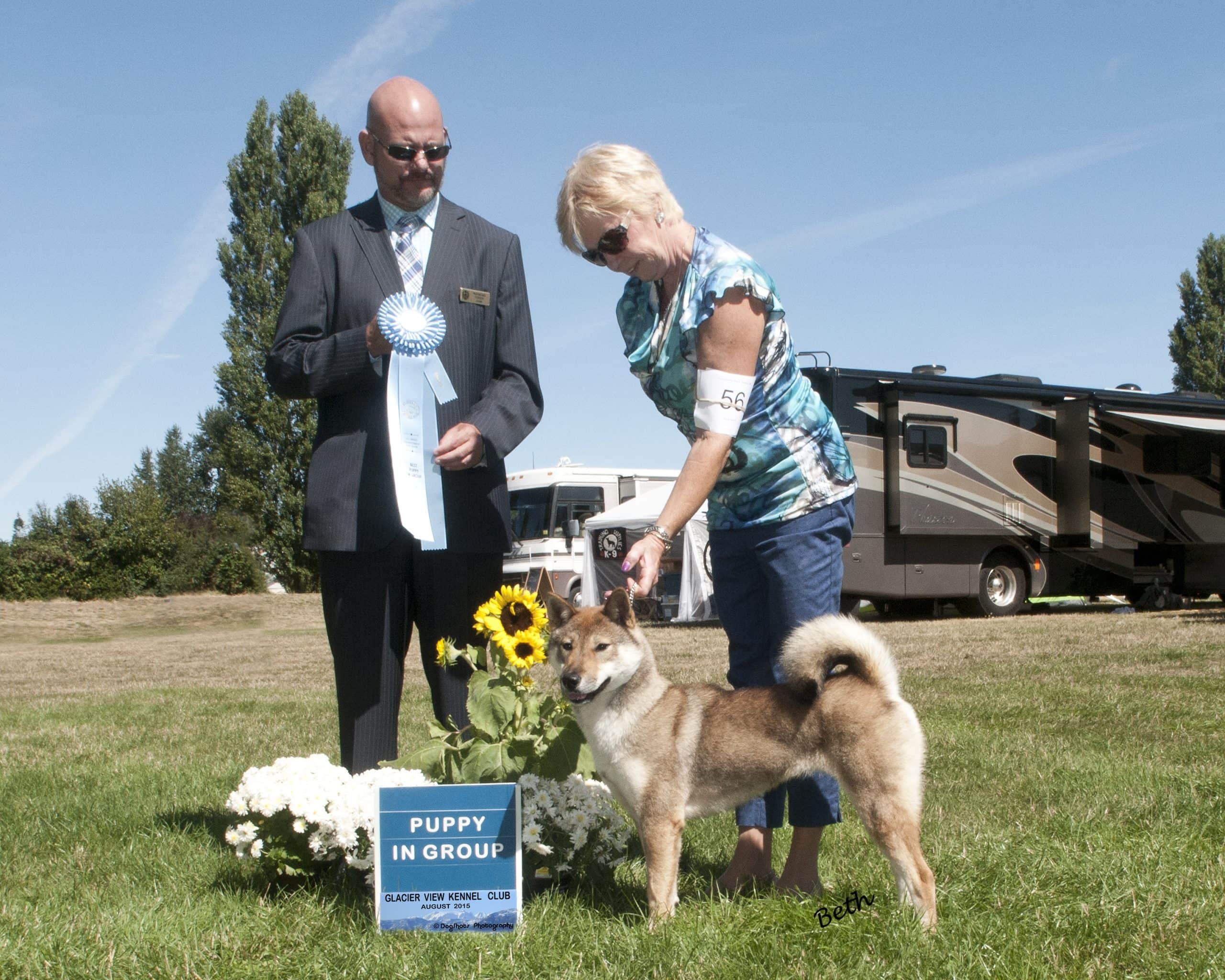 Judge and handler with dog and show ribon