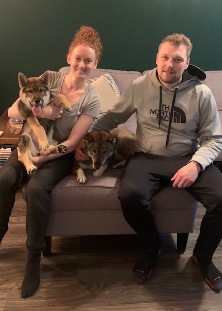 man and women with puppy sitting on a bench